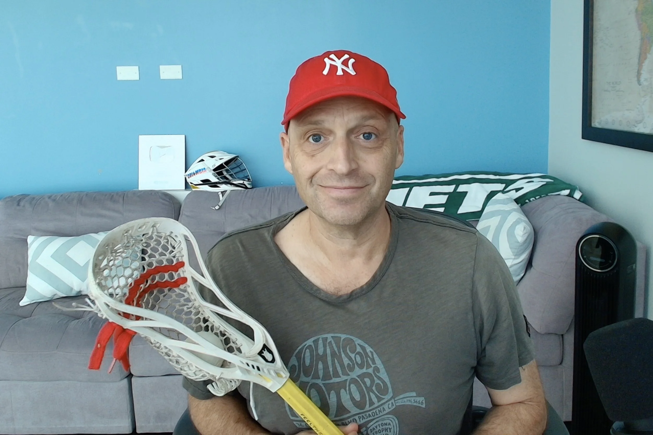 Joe holding a lacrosse stick at home.