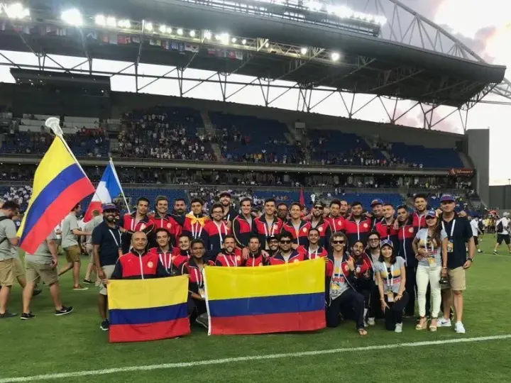 Athletes in red, navy, and white uniforms holding Colombia flags.