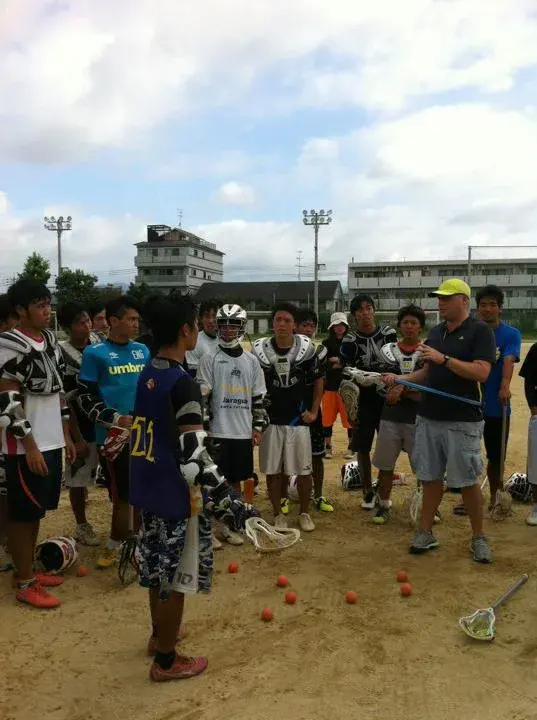 Lacrosse team listening to a coach during practice.